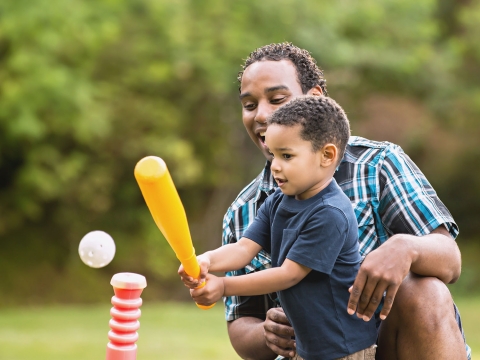 News for Parents image: father teaching son how to hit a baseball